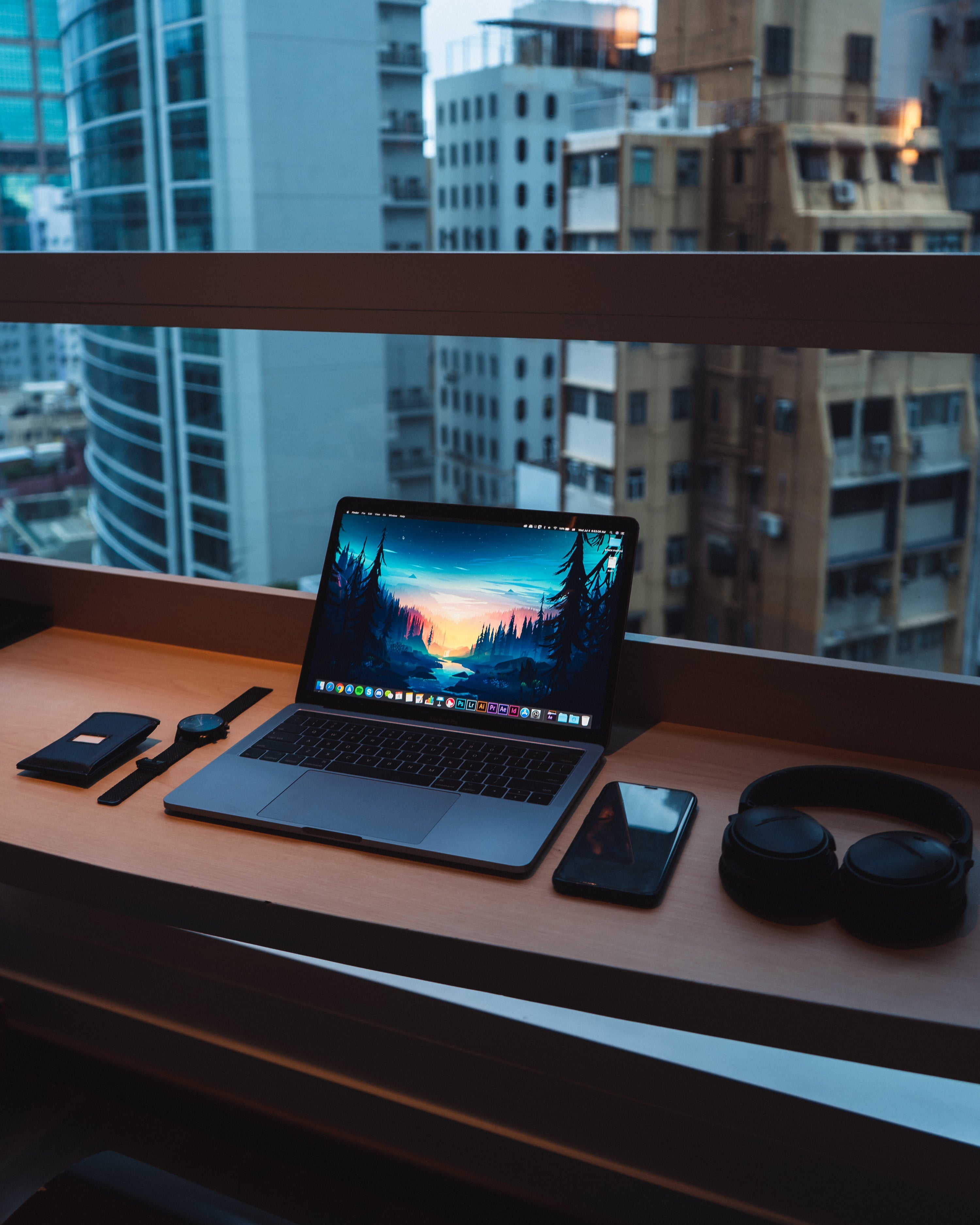 organized desk with computer sitting by window in city